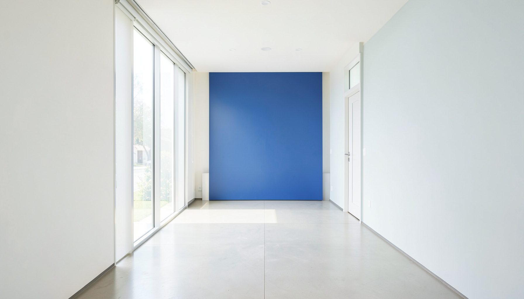 A bright, airy clinic interior with clean lines, pale walls, and natural light streaming through large windows, conveying a calm and professional healthcare environment.