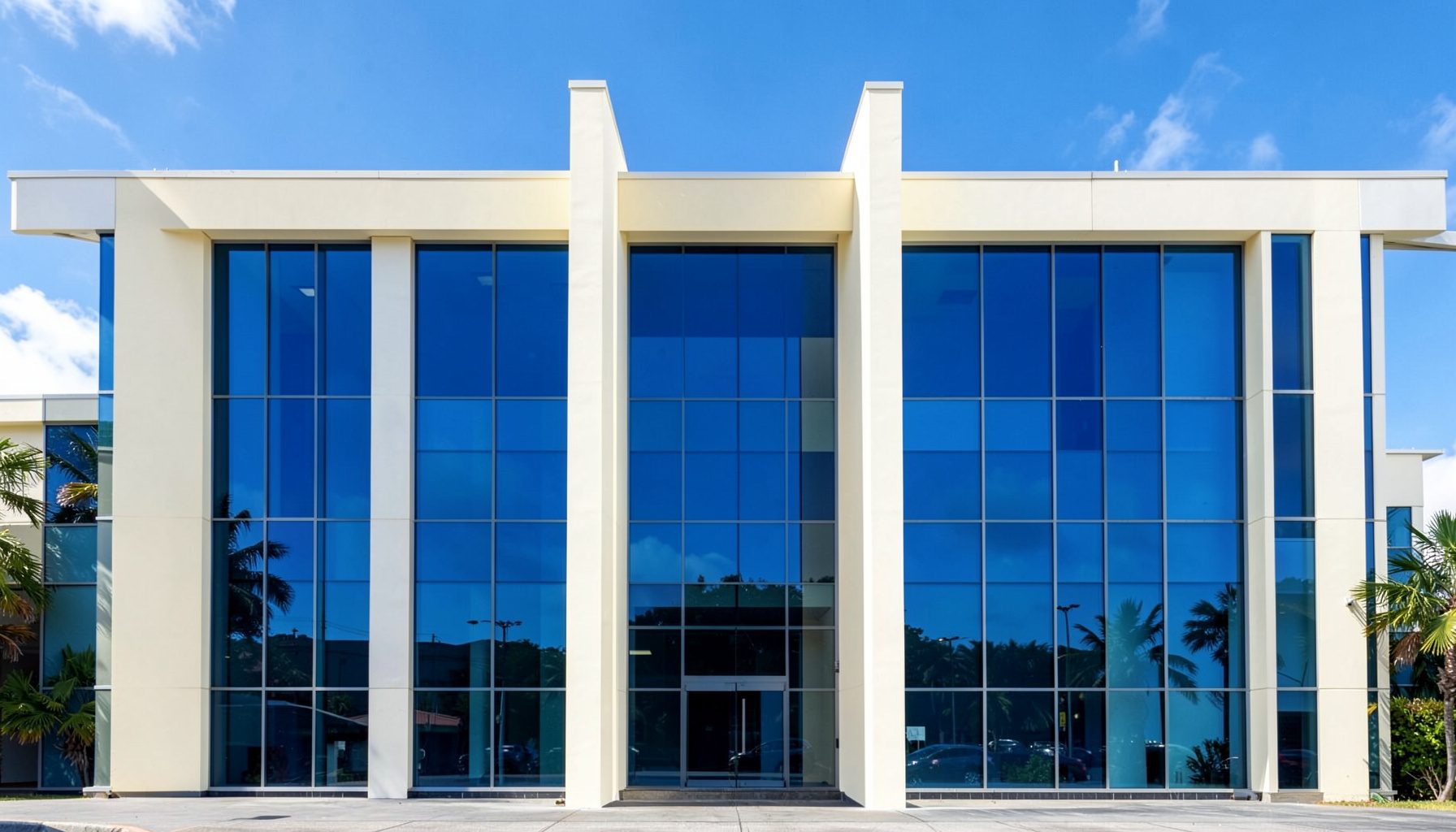 A clean architectural photograph of a modern government building facade in Kingston, featuring strong symmetrical lines